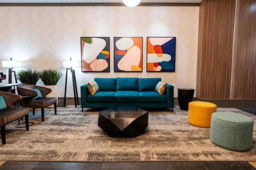 sala de estar con sofá azul y algunas sillas en Sandman Suites Vancouver on Davie, en Vancouver