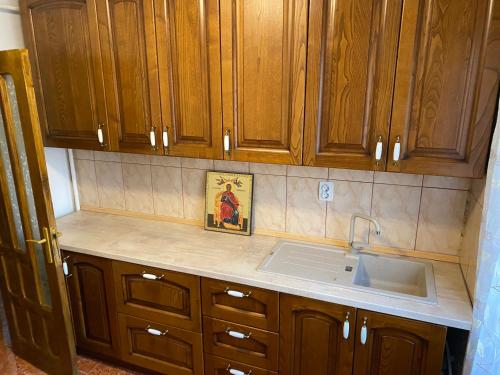 a kitchen counter with wooden cabinets and a sink at Apartament lux 3 camere in Roman
