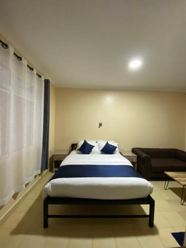 a bedroom with a large bed and a couch at Todas Hotel in Kiambu