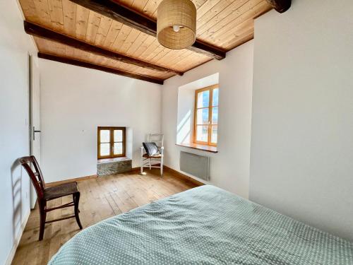 une chambre avec un lit et un plafond en bois dans l'établissement Authentique Maison Familiale rénovée près du lac 