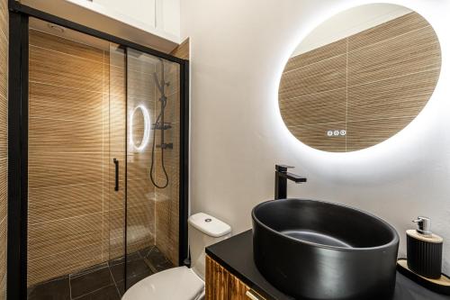 La salle de bains est pourvue d'un lavabo noir et d'une douche. dans l'établissement 34 BORNIOL - Bel appartement rénové avec mezzanine Cannes, à Cannes