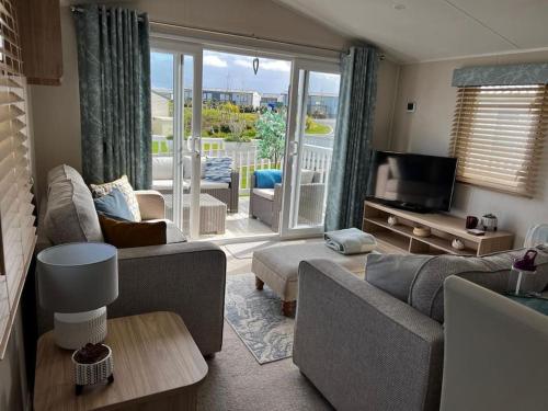 a living room with a couch and a tv at Sandy Bay Caravan Getaway in Newbiggin-by-the-Sea