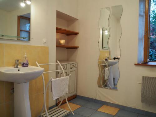 une salle de bain avec un lavabo et un miroir dans l'établissement Authentique Maison Familiale rénovée près du lac 