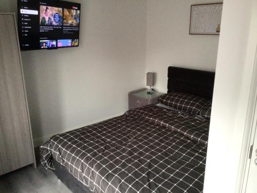 a bedroom with a bed and a tv on the wall at Exclusive Lakeside Apartment in Grays Thurrock