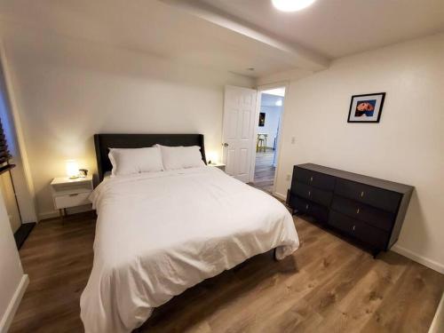 sypialnia z dużym białym łóżkiem i drewnianą podłogą w obiekcie Updated Douglas Apartment, Near Downtown and Skiing w mieście Juneau