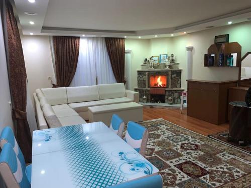 ein Wohnzimmer mit einem Sofa, einem Tisch und einem Kamin in der Unterkunft Villa Kartalkaya in Kındıra
