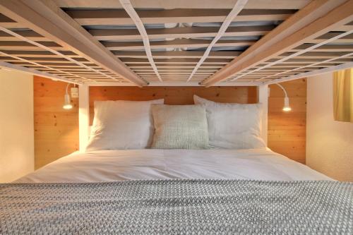 a bed in a room with a wooden ceiling at Mossettes 5, Penthouse Sunny Terrasse And Sauna in Champéry