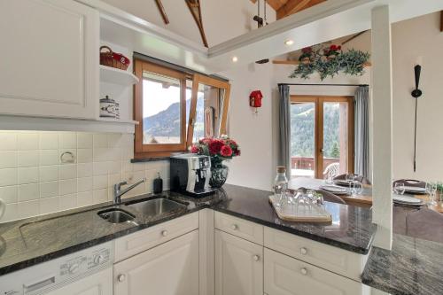 eine Küche mit einer Spüle und einer Arbeitsplatte in der Unterkunft Penthouse With Sunny Balcony And Sauna in Champéry