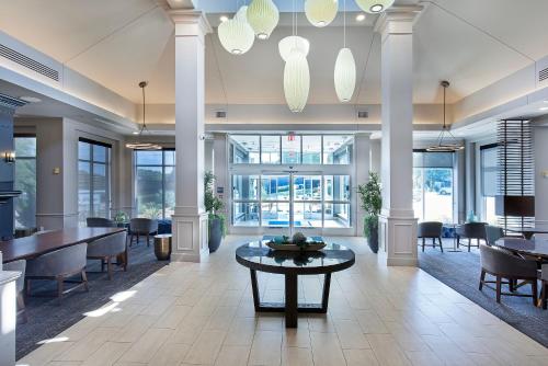 an office lobby with tables and chairs and windows at Nash Haus Hotel in Nashville