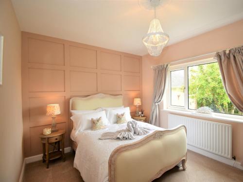 Schlafzimmer mit einem Bett, einem Fenster und einem Kronleuchter in der Unterkunft 3 Bed in Cockermouth 82438 in Dearham
