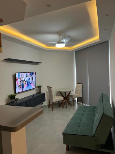 a living room with a couch and a flat screen tv at Summit Flat Exclusivo Proximo ao center Vale shopping in São José dos Campos