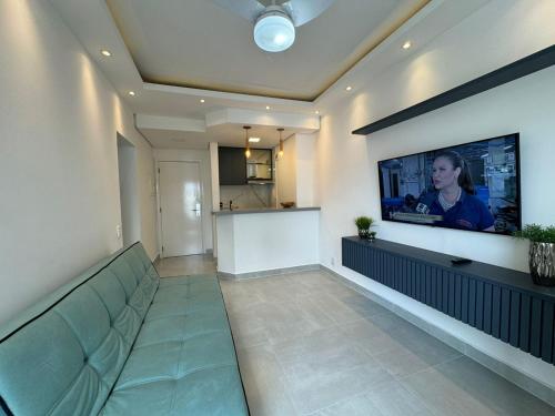 a living room with a couch and a flat screen tv at Summit Flat Exclusivo Proximo ao center Vale shopping in São José dos Campos