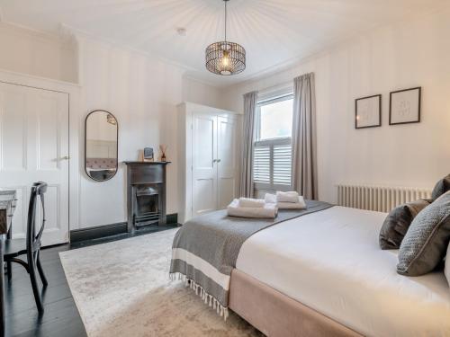 een witte slaapkamer met een bed en een spiegel bij 2 Bed in York 94487 in York