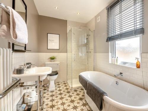 een badkamer met een bad, een wastafel en een toilet bij 2 Bed in York 94487 in York