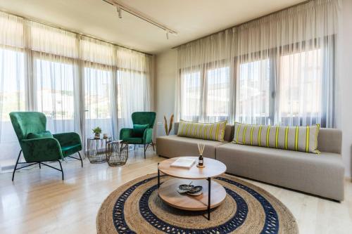 a living room with a couch and chairs and windows at Casa Blue Hotel, Philian Hotels and Resorts in Skiathos