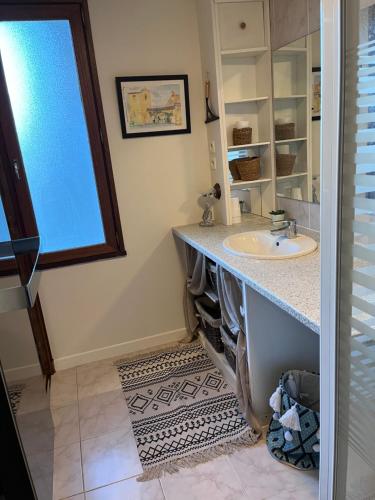 een badkamer met een wastafel en een raam bij Cottage Apolline in Santenay