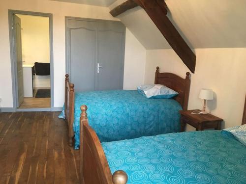 a bedroom with a bed with a blue bedspread at Maison de campagne en Périgord noir in Nadaillac