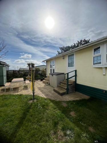 a house with a patio and a table at Lovely spacious lodge on Trimingham house caravan park, near Cromer and Mundesley in Trimingham