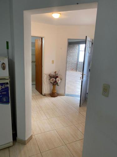 einen Flur mit einer Tür und einer Vase aus Blumen in der Unterkunft Departamento amoblado 3534290534 in Villa María