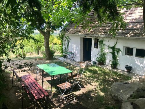 a table and chairs in front of a white house at Kofal Pince in Raposka