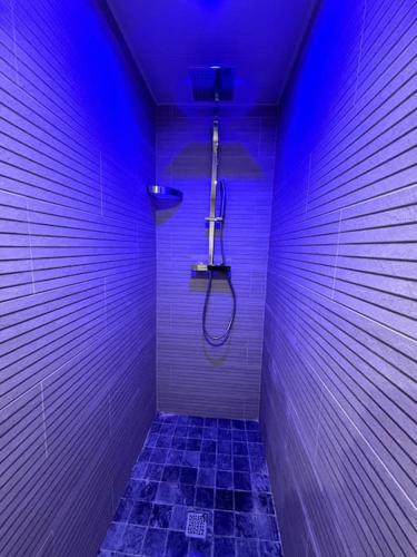 une salle de bain avec des lumières violettes sur le mur dans l'établissement Appartement cosy 90m²/ 6 personnes, à Ternay