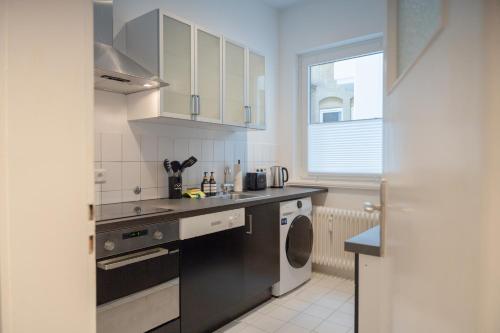 a kitchen with a sink and a washing machine at Modernes Apartment 4 Personen Zentral 56qm WLAN gehobene Ausstattung in Hannover