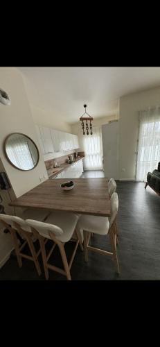 une cuisine avec une grande table et des chaises en bois dans l'établissement Appartement 3 pièces, à Bobigny