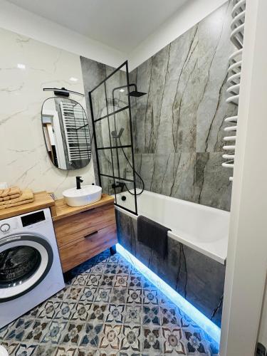 a bathroom with a tub and a sink at Apartamenty Dębowa 10 in Milicz