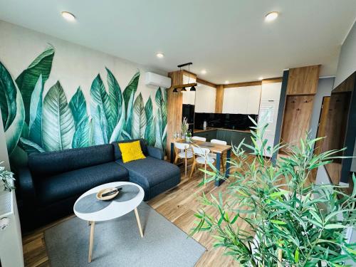 - un salon avec un canapé et des plantes dans l'établissement Apartamenty Dębowa 10, à Milicz