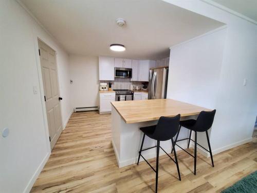 a kitchen with a wooden table and two chairs at Updated Douglas Apartment, Close to Sandy Beach in Juneau