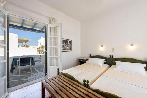2 camas en una habitación con banco y balcón en Zanneta's House, en Naousa