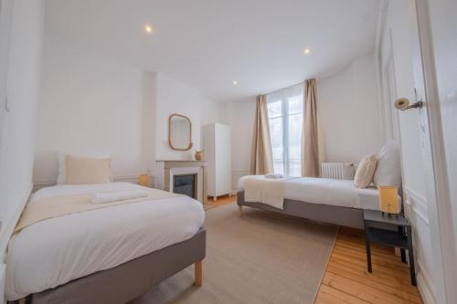 une chambre avec deux lits et une cheminée dans l'établissement Sommet Remois Cathedrale, à Reims