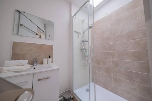 une salle de bain blanche avec une douche et un lavabo dans l'établissement Sommet Remois Cathedrale, à Reims