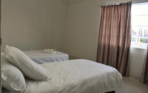 a hotel room with two beds and a window at Farmhouse Boutique Backyard Rooms in Outjo