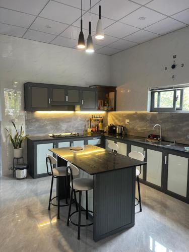 a kitchen with a large island with bar stools at Cle homestay in Hue