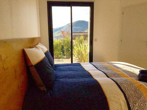 een slaapkamer met een bed en uitzicht op een raam bij Appartement & Jacuzzi dans l’Esterel proche Mer in Les Adrets de l'Esterel