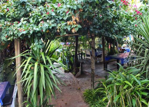 a garden with a pergola with a bench and plants at Farmhouse Boutique Backyard Rooms in Outjo