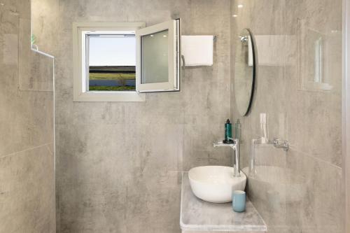 a bathroom with a sink and a mirror and a shower at Windmillside Luxury Villas in Emporio Santorini