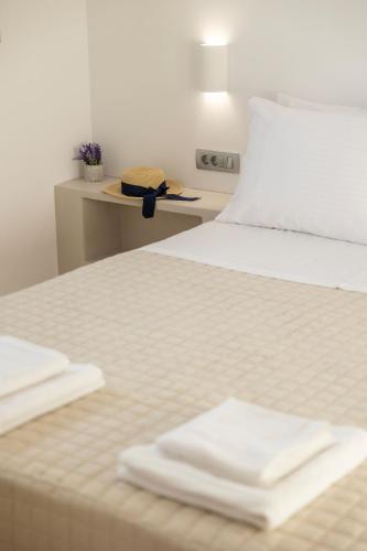 a bed with two white towels sitting on it at Windmillside Luxury Villas in Emporio Santorini