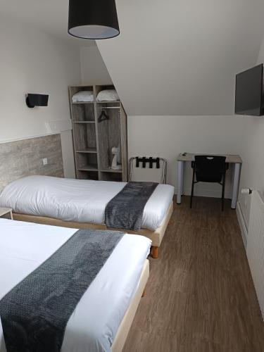 Ce lit se trouve dans un dortoir doté d'un bureau et d'une table. dans l'établissement Le Relais Du Velors, à Beaumont-en-Véron