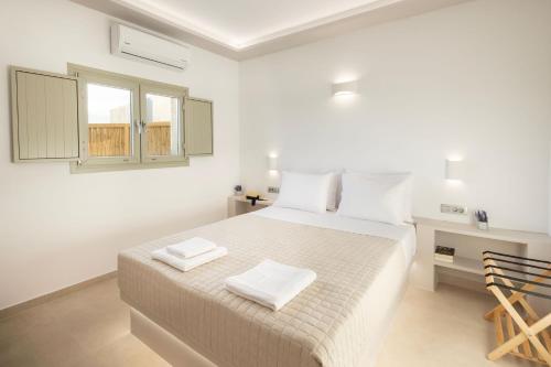 una camera da letto con un letto con due asciugamani bianchi di Windmillside Luxury Villas a Emporio
