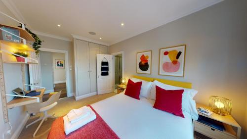 ein Schlafzimmer mit einem großen weißen Bett mit roten Kissen in der Unterkunft Madison Hill - White Hill House 4 - 2 bedroom flat in London
