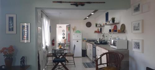 a kitchen with a refrigerator and a table and chairs at Breezy Vista on the Terrace - West Coast, Saint James, Barbados in Saint James
