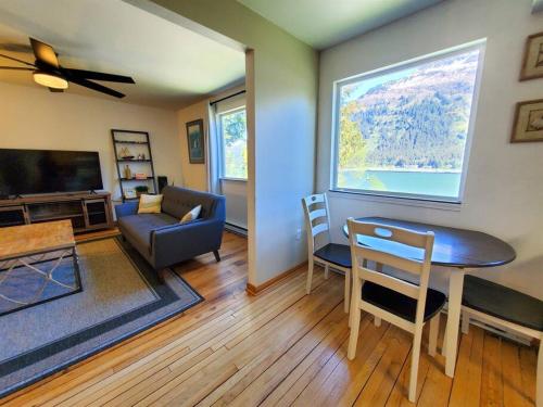 a living room with a couch and a table and a window at Ocean and Mountain View Home, near Downtown Juneau in Juneau