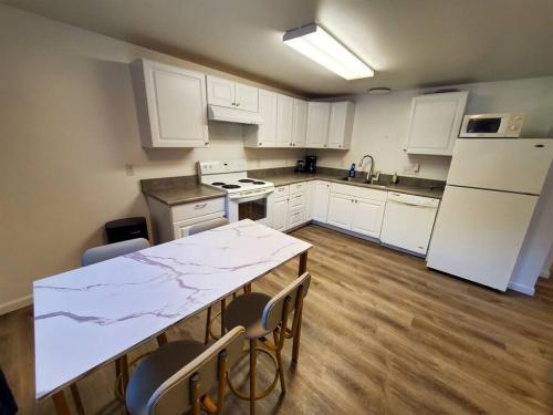 a kitchen with white cabinets and a table with chairs at Ocean and Mountain View Home, near Downtown Juneau in Juneau
