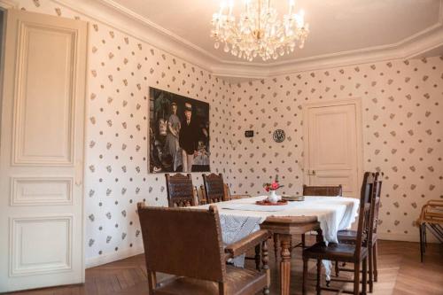 une salle à manger avec une table, des chaises et un lustre dans l'établissement Waterfront Manoir near Paris, Champagne and Disney, à La Ferté-sous-Jouarre
