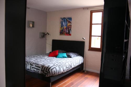 Dormitorio pequeño con cama y ventana en Andraud en Issendolus