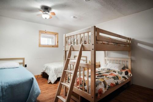 a bedroom with two bunk beds and a bed at Hot Tub, River&Kayak, WiFi, & Fire Pit at Cabin! in Morton Grove