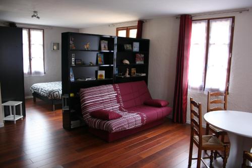 Issendolus的住宿－Andraud，客厅配有红色沙发和书架