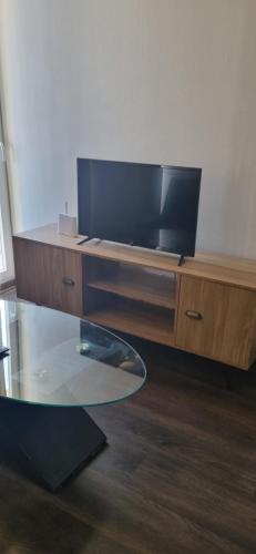 a living room with a tv and a glass table at Condominio en La Florida in Santiago
